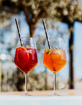 Refreshing Fiuman and Fiumanka spritz cocktails served in wine glasses with the Suza T.B. logo