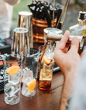 Preparing a Laval Pelinkovac cocktail – served with ice and orange slice